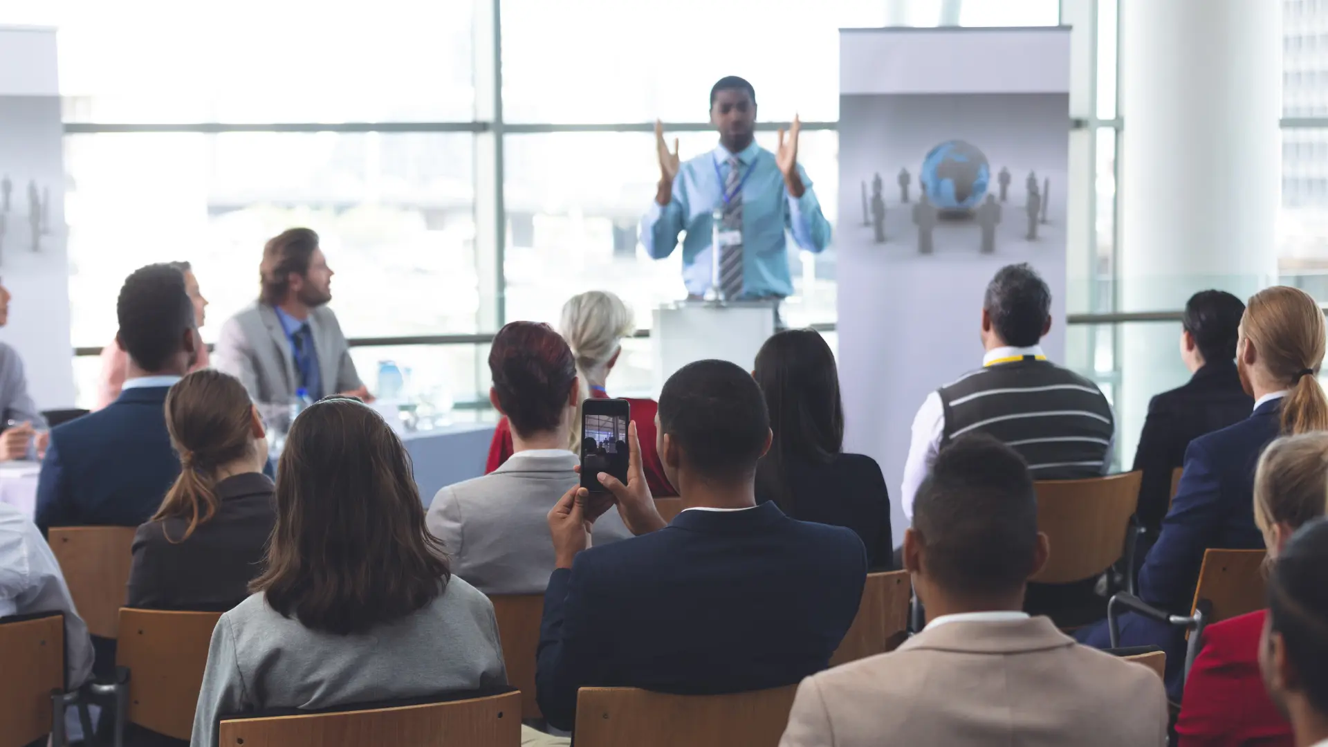 A speaker presenting to a seated audience at the International Conference on Gender and Society