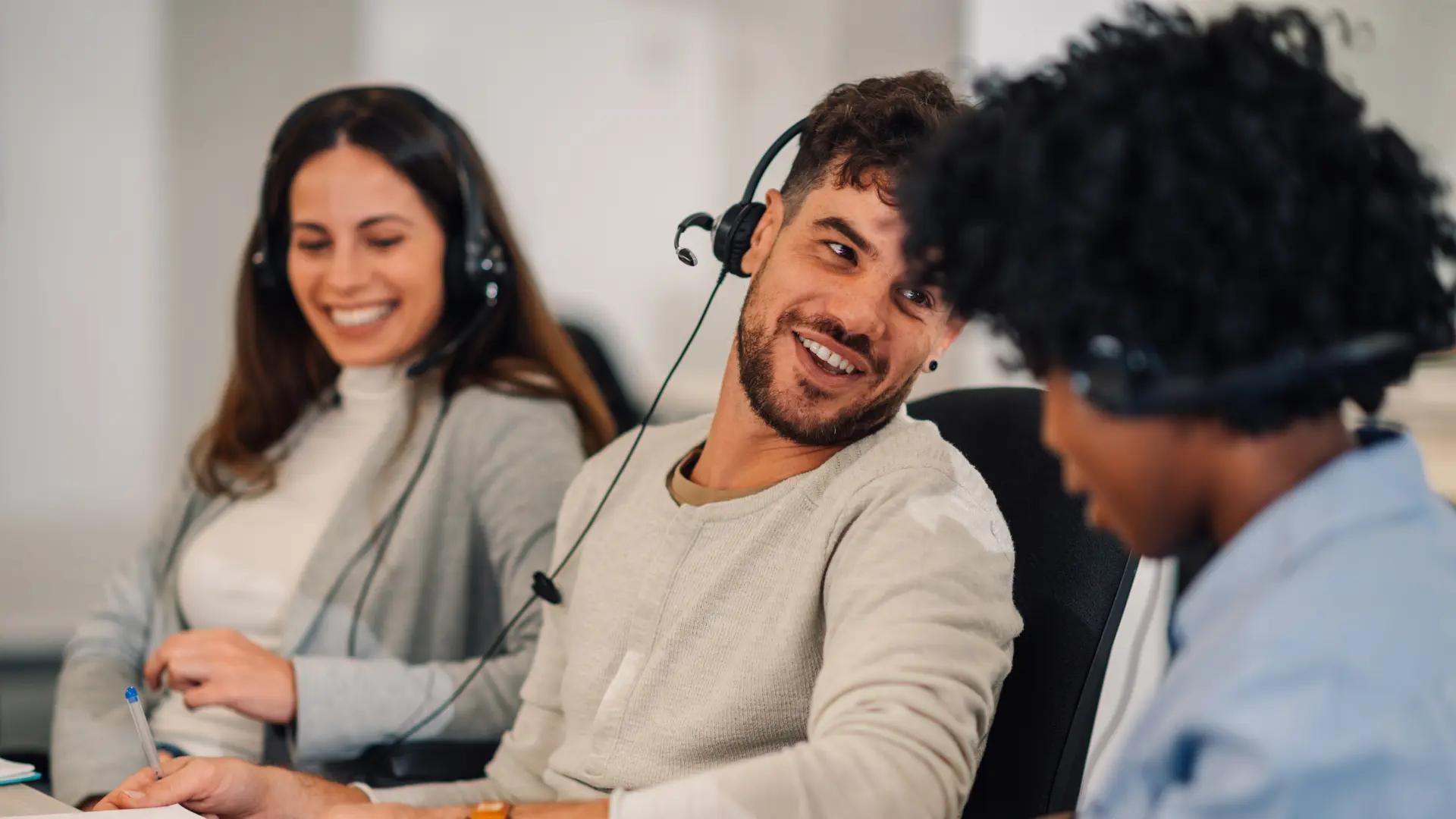 A smiling support team wearing headsets, ready to help